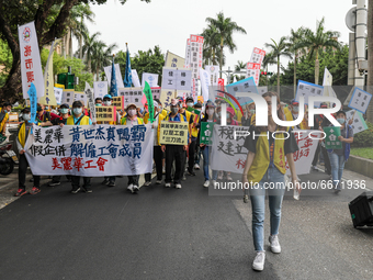 Protesters marching with flags, banners and signs in while shouting slogans (asking for minimal monthly salary raise) while lifting up their...