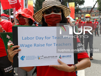 Protester standing with sign reading:  “Labor day for Teachers” and “Wage Raise for Teachers”. , in Taipei, Taiwan, on May 1, 2021 duing the...