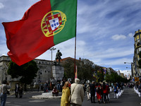 A participant of the labor day march walks with a Portuguese flag. Lisbon, May 01, 2021. Hundreds of people participated today in Portugal i...