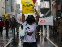 A woman holds a banner in the rain with a message in Spanish that reads: Sanctions are a crime, during a march to celebrate International Wo...