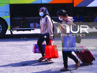 Prospective passengers carry their luggage at the Kampung Rambutan Station, Jakarta, Indonesia, Monday 3 May 2021. The government enforces a...