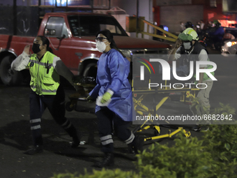 Paramedics transfer an injured person on a stretcher to be taken to a hospital after the collapse of a structure on Line 12 Metro in Mexico...