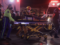 Paramedics transfer an injured person on a stretcher to be taken to a hospital after the collapse of a structure on Line 12 Metro in Mexico...
