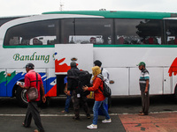 Passengers load their baggages onto a bus to return to their hometowns known locally as 