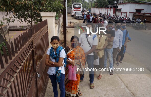 People taking Covid-19 coronavirus vaccine and other are seen in the queue as they wait for their turn for vaccination in the eastern Indian...