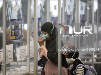A woman blow air to plastic as part of Covid19 ''Genose'' system in Jakarta, Indonesia, on 05 May 2021. People filled in senen station, jaka...