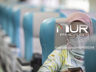 A woman sit at the train for Malang, East Java destination in Jakarta, Indonesia, on 05 May 2021. People filled in senen station, jakarta fo...