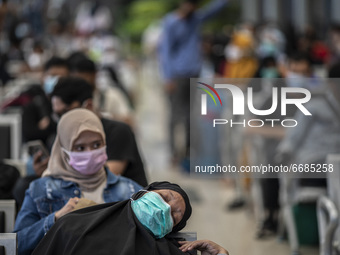 A woman fell a sleep while waiting for the train in Jakarta, Indonesia, on 05 May 2021. People filled in senen station, jakarta for coming h...