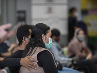 A man on protecting her pregnant wife while waiting for the train come  in Jakarta, Indonesia, on 05 May 2021. People filled in senen statio...