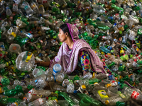 Woman labourers sort through polyethylene terephthalate (PET) bottles in a recycling factory in Dhaka, Bangladesh, on May 5, 2021. Recycling...
