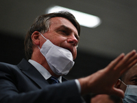 Brazil's President Jair Bolsonaro speaks to journalists wearing a protective face mask on the chin during a press conference amidst the Coro...