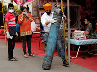 A man having difficulty in breathing, is attended by a volunteer as he receives free oxygen support outside a Gurudwara (Sikh temple) in Gha...
