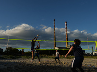 A group of friends, consisting of Brazilians, Russians, Lithuanians, French and Italians, playing beach volleyball at Poolbeg Beach, Dublin,...