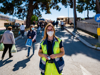 A volunteer in charge of measuring the temperature of the people passing through the weekly market poses for a photo in Molfetta on May 6, 2...