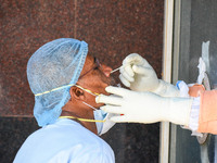 A health worker collects a swab sample of a man for COVID-19 testing at a hospital in Kolkata , India , on 7 May 2021 . Indian government ha...