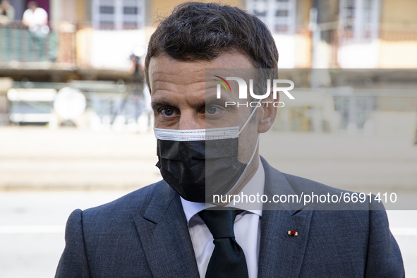 French President Emmanuel Macron wears a protective mask as he talks to journalists while arriving in Alfandega building to participate of t...