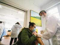 a woman receives her vaccination during the start of another vaccination project in Koelnberg, which is  one of high infection districts in...