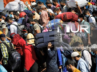 Migrant workers get into an overcrowded ferry to reach home to celebrate Eid-Ul-Fitr during a government imposed lockdown amid Covid-19 Pand...