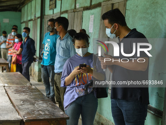 Youth in queue maintaining social distancing to take vaccine against COVID-19 coronavirus disease, at a vaccination centre, in Guwahati, Ind...