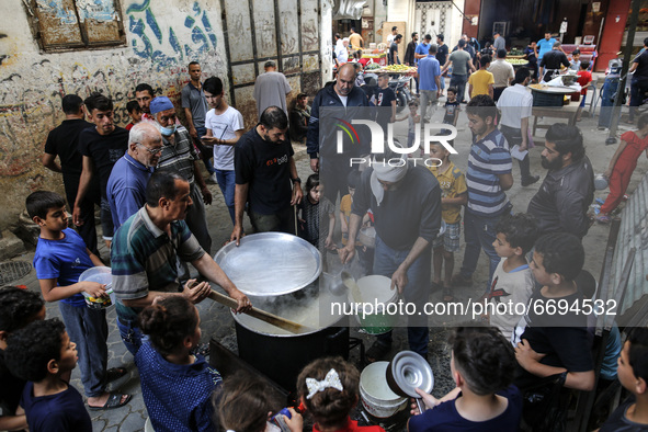 Palestinians wait to get soup offered for free during the Muslim fasting month of Ramadan, on May 8, 2021. amid coronavirus disease (COVID-1...