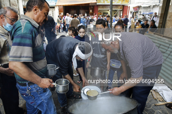 Palestinians wait to get soup offered for free during the Muslim fasting month of Ramadan, on May 8, 2021. amid coronavirus disease (COVID-1...