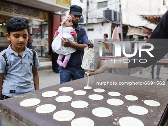 A Palestinian makes traditional sweets known as ,Qatayef, a dessert typically for the holy month of Ramadan, at a market in Gaza City, on Ma...