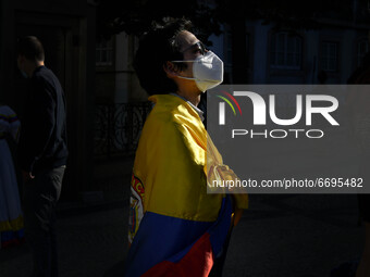 A protester wearing a protective mask is wrapped in a Colombian flag during the rally in Luis de Camões square, Lisbon. 08 May 2021. Colombi...