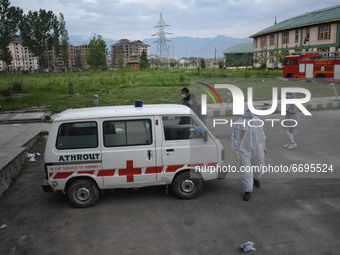 Attendants along with the Covid-19 patient board the ambulance at a temporary hospital in Srinagar, Indian Administered Kashmir on 08 May 20...