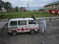 Attendants along with the Covid-19 patient board the ambulance at a temporary hospital in Srinagar, Indian Administered Kashmir on 08 May 20...