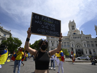 A protester carrying a placard and wearing a Colombian flag during a demonstration in support of Colombian people and against violence in th...