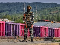 A Central Reserve Police Force (CRPF Cop) is seen at a temporary check point during COVID-19 Corona Curfew in Baramulla, Jammu and Kashmir,...