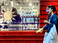 People wearing face masks walk past a Taiwan  flag outside a clothing store, amid the global pandemic Covid-19 and rising tensions with Chin...