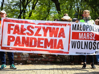 People hold 'False Pandemic' banner while demonstrating without wearing face masks during anti-vaccination and anti-coronavirus restrictions...