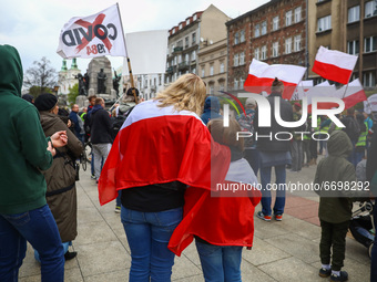 People demonstrate holdin Polish flags during anti-vaccination and anti-coronavirus restrictions Freedom March in Krakow, Poland on May 8, 2...
