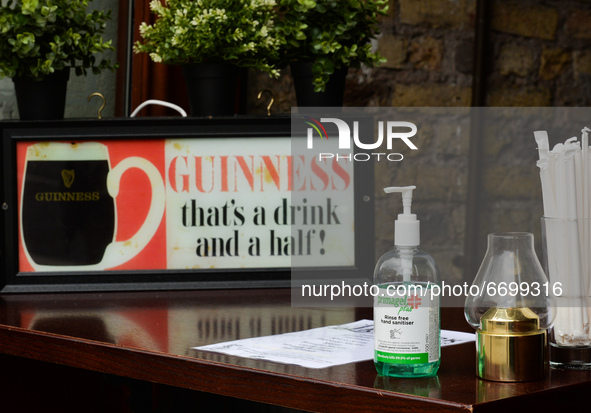A hand sanitizer on the table that serves as a take-away desk at the entrance to a pub in Dublin city center, during the final days of the C...