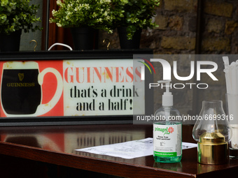 A hand sanitizer on the table that serves as a take-away desk at the entrance to a pub in Dublin city center, during the final days of the C...