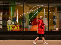 A person walks past Marks and Spencer's window with a sticker that reads 'Bring On Summer' in Dublin city center, during the final days of t...
