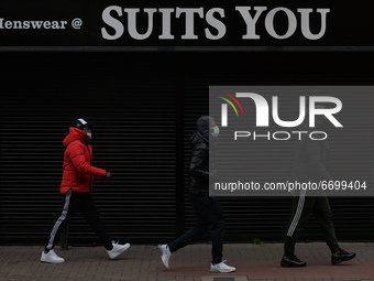 Three young men walk past by a closed Menswear 'Suits You' store in Dublin city center.
On Sunday, 9 May 2021, in Dublin, Ireland. (