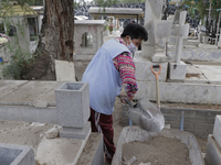 A woman cleans her mother's grave inside the Panteón del Pueblo de Culhuacán cemetery in Mexico City on the eve of Mother's Day to be held t...
