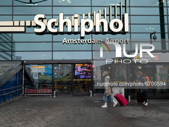 Entrance of Schiphol Airport with people wearing face mask. Amsterdam Schiphol International Airport during the Covid-19 pandemic. Reduced p...