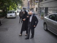 An Iranian woman helps her elderly father while arriving a health center for receiving a dose of China's Sinopharm new coronavirus disease (...