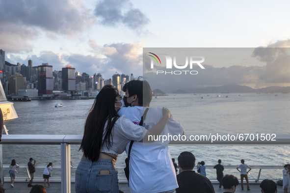 A Couple kiss while looking at the sunset in Hong Kong, Monday, May 10, 2021. 