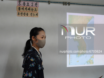 A teacher wearing a face mask and a Korean traditional dress conducts a Korean class at Hiroshima Korean School on May 9, 2021 in Hiroshima,...