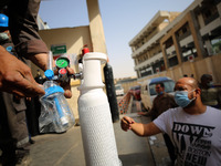 Workers fill in the oxygen cylinders used for Covid-19 patients before they are sent to hospitals and citizens buy them for isolation patien...