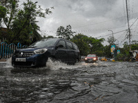 various vehicles tries to make their way through a flooded road after heavy monsoon rain in Kolkata , India , on 11 May 2021 . (