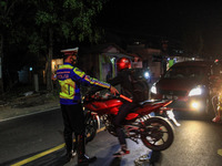 Indonesian Police officers stand at a checkpoint to return the motorist as Indonesian authorities ban annual mass migration, known as 'Mudik...