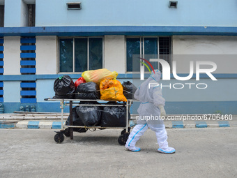 A health worker disposes of COVID-19 waste at a hospital in Kolkata , India , on 12 May 2021 . India reports over 4200 deaths and nearly 3.5...