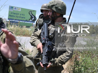 Israeli soldiers hold positions at Netiv Ha'Asara near the site where an IDF vehicle was directly hit by a rocket fired from Gaza strip, inj...