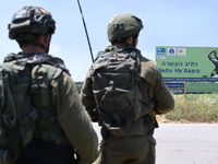Israeli soldiers hold positions at Netiv Ha'Asara near the site where an IDF vehicle was directly hit by a rocket fired from Gaza strip, inj...