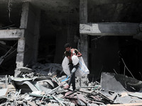 A Palestinian man walks at the rubble of the severely damaged Al-Jawhara Tower in Gaza City on May 12, 2021 after it was hit by Israeli airs...